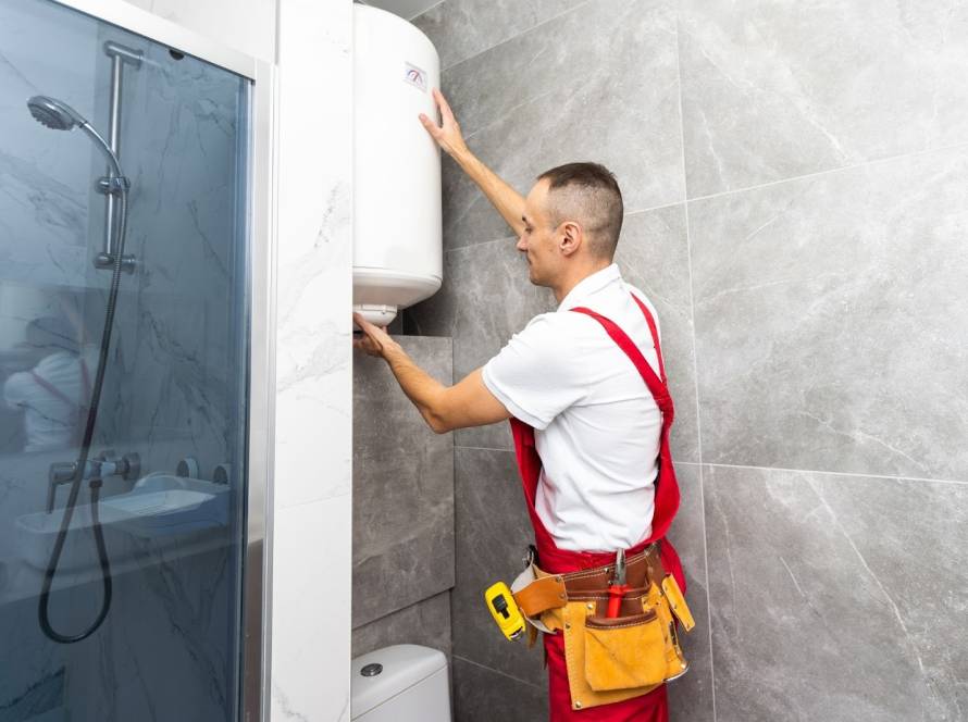 Licensed technician installing a new water heater in a residential bathroom