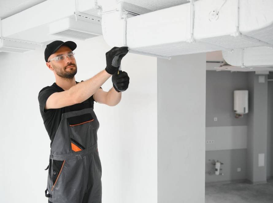 Professional HVAC technician performing duct cleaning and ventilation system inspection