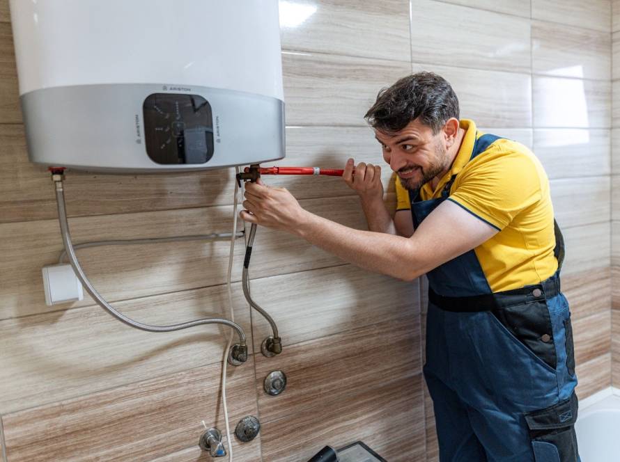 Plumber repairing a water heater in a modern bathroom
